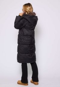 Czarny, ocieplany długi płaszcz z kapturem i sztucznym futrem, z pikowanym wzorem, funkcjonalnymi kieszeniami i gładką, błyszczącą teksturą.