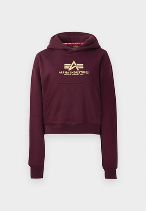 Bordový zkrácený mikinový svetr vyrobený z měkké tkaniny, s přední kapsou a zlatým logem "Alpha Industries" s stylizovaným písmem.