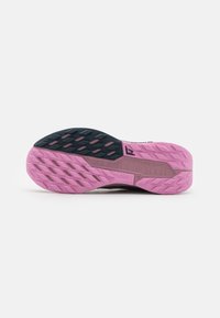 La semelle extérieure des chaussures Nike présente une palette de couleurs rose et noire avec une surface texturée et un motif de traction en zigzag pour une meilleure adhérence.