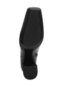 Suela de zapato de tacón alto negro con acabado liso y mate y patrón de agarre de goma. Forma contorneada y área de puntera reforzada.