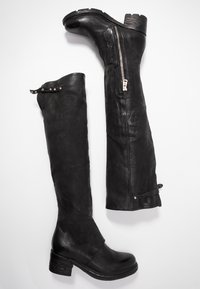 Botas negras de cuero hasta la rodilla con un tacón de bloque de madera, que cuentan con un cierre lateral, tachuelas decorativas y un acabado suave y texturizado.