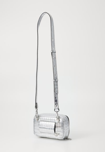 Silver metallic crossbody bag with crocodile texture, rectangular shape, adjustable strap, zip closure, and a front pocket detail.
