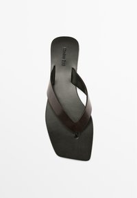 Black leather flip-flop with a V-shaped strap design. Smooth texture with a flat sole and minimal branding on the footbed.