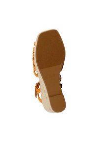 Strappy sandal with a light orange upper, textured rubber sole, and a cork-like midsole. Features adjustable buckles near the heel.