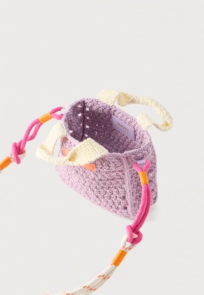 Μικρή πλεκτή τσάντα χειρός σε λιλά χρώμα με κρεμ χερούλια και αποσπώμενο ροζ, πορτοκαλί και λευκό πλεγμένο λουρί σε λευκό φόντο.