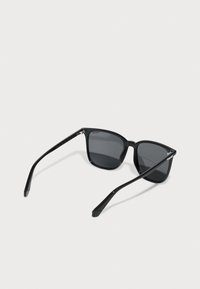 Black sunglasses with a glossy finish, square lenses, and thin, straight temples. Features a subtle logo on the left temple.