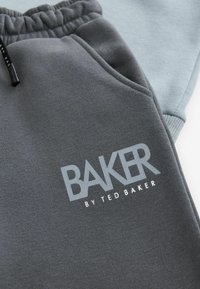 Mørkegrå sweatpants med elastisk talje og lommer, med et lyst grå "BAKER by TED BAKER" logo. Blødt bomuldsblandingsmateriale.