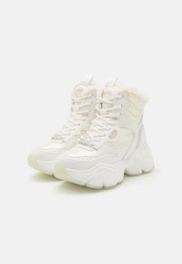 White high-top sneakers made of synthetic leather with a fur-lined collar, thick sole, and lace-up design featuring silver hardware accents.