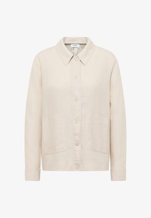 Beigen värinen napillinen takki, jossa on terävä kaulus, pitkät hihat, kaksi etutaskua ja suora helma.