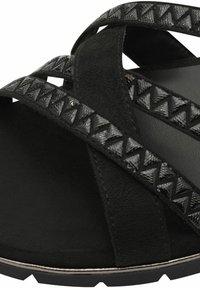 Sandalo nero con multiple cinghie incrociate e motivi geometrici. Texture in suede morbido e suola in gomma con bordo seghettato per una migliore aderenza.