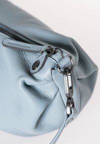 Borsa in pelle blu chiaro con superficie texturizzata, dotata di chiusura a zip e di un gancio in metallo con branding incisa.