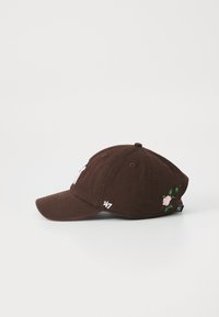 Cappellino da baseball marrone in cotone, con un design ricamato di fiori sul lato e etichetta con logo sulla parte sottostante del visiera.
