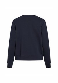 Tamsiai mėlynas džemperis su apvaliu kaklu, ilgomis rankovėmis ir įsiūktais rankogaliais. Audinys atrodo minkštas, su lygia tekstūra ir minimaliais detalėmis.