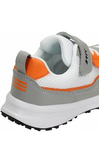 Baskets avec une tige en maille blanche, des accents gris et un talon orange. Comprend une sangle à boucle et une semelle en caoutchouc texturé.