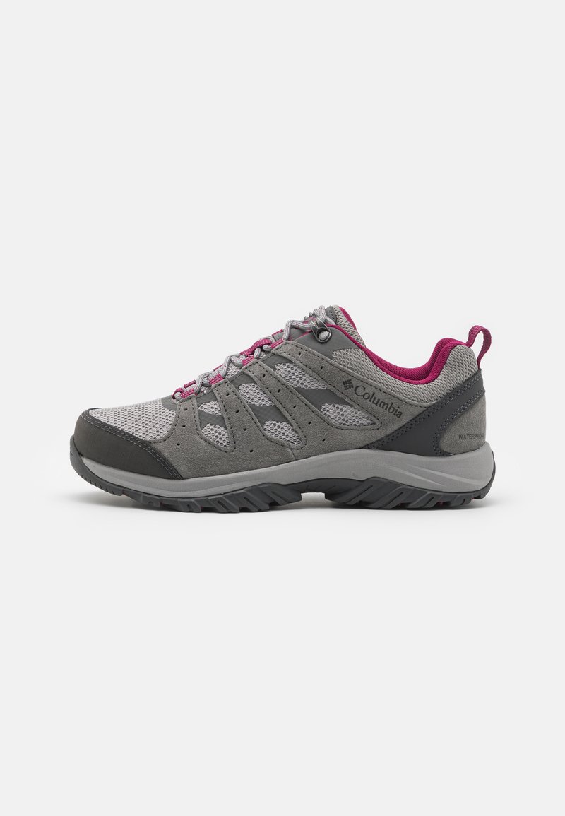 Chaussure de randonnée grise en matériaux mesh et daim, avec des accents roses, semelle en caoutchouc et coque de protection pour les orteils. Présente un design respirant.