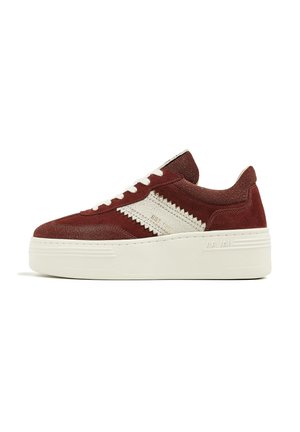 Low platform sneaker in dark red suede with white zigzag stripe, white laces, and thick off-white sole with "VIA VIA" embossed.