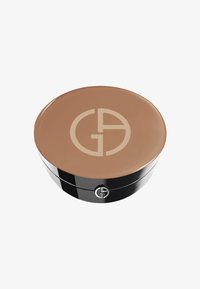 Compatto rotondo con una crema liscia di colore marrone chiaro all'interno. Il coperchio presenta un logo beige su una superficie lucida, con una base nera.