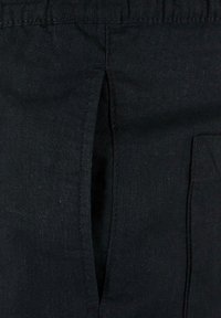 Czarna tkanina lniana z pionowym otworem i boczną kieszenią. Tekstura wydaje się nieco szorstka, z widocznym przeszyciem wzdłuż krawędzi.