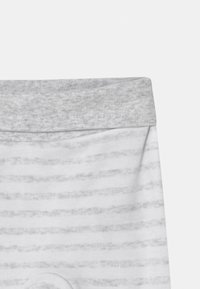 Grå og hvite stripete leggings med en myk elastisk midjebånd og glatt tekstur, designet for komfort og bevegelsesfrihet.