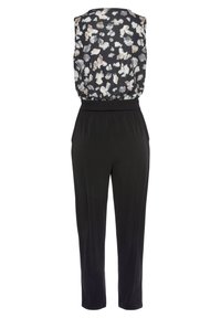 Zwarte jumpsuit met een bloemenpatroon bovenkant in creamy en grijze tinten, voorzien van een smocktail en taps toelopende broekspijpen.