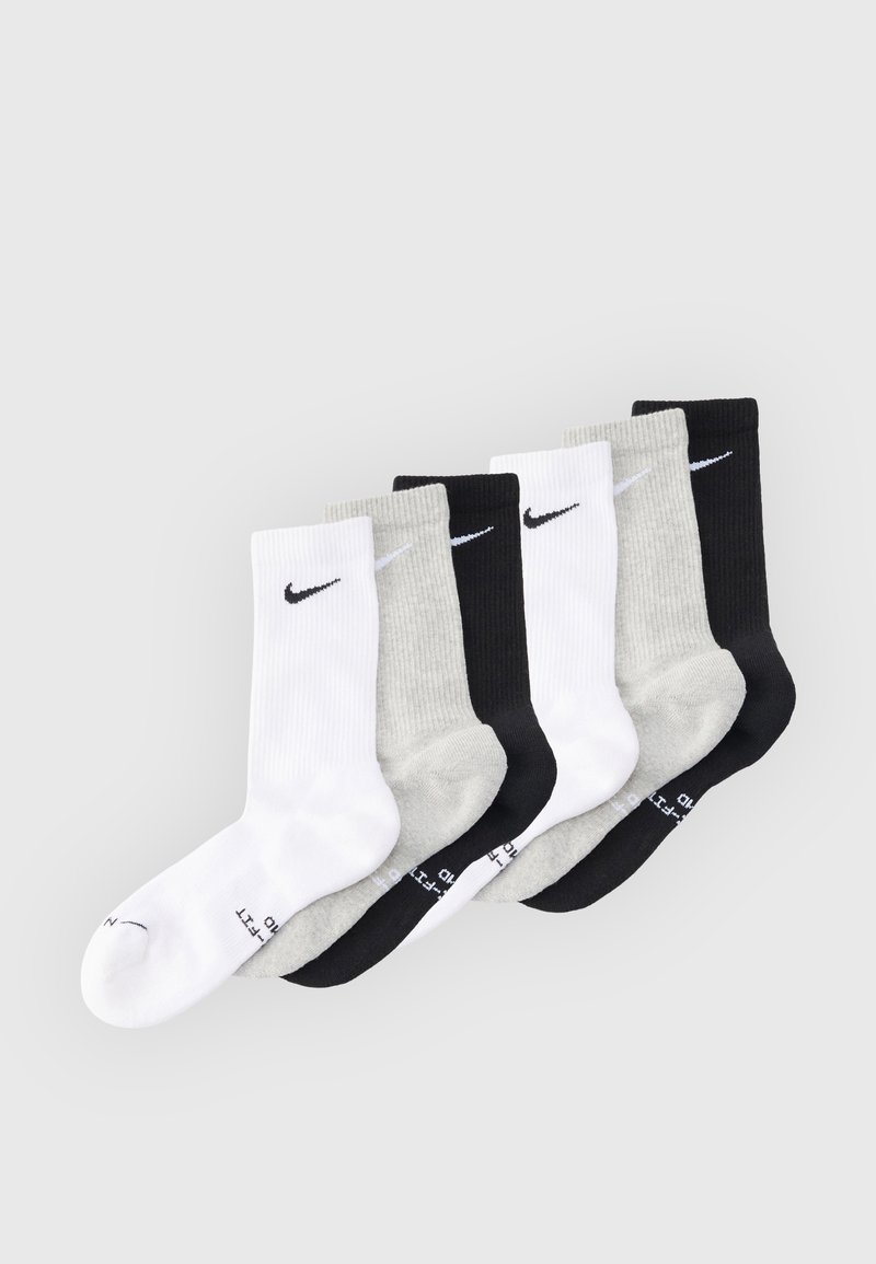 Έξι ζευγάρια κάλτσες Nike σε λευκό, γκρι και μαύρο, τοποθετημένα επικαλυπτόμενα πάνω σε απλό ανοιχτό φόντο.