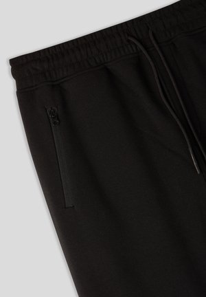 Pantaloni sportivi neri con vita elastica e cordoncino. Presentano una tasca laterale con zip e un tessuto morbido e testurizzato.