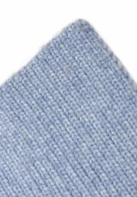 Light blue knitted fabric with a ribbed texture, displaying a soft, fine yarn. The material is uniform with no visible patterns or hardware.