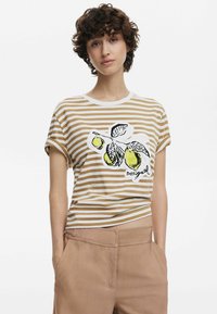 Randig bomulls-t-shirt i beige och vitt med en grafik av gröna citroner och blad. Har uppvikta ärmar och en avslappnad passform.