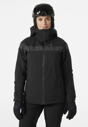 Black ski jacket featuring a high collar, zip closure, and gray accents. Paired with black gloves and a helmet, showcasing a sleek, functional design.