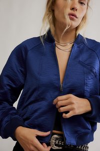 Modrá bomber bunda z hladké, lesklé látky s předním zipem, žebrovanými manžetami a dvěma předními kapsami s jemným leskem.