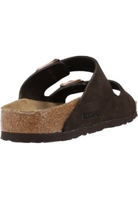 Sandale à glissière en daim marron avec semelle en liège, design ouvert et deux brides réglables. Elle dispose d'une semelle texturée pour une meilleure adhérence et stabilité.