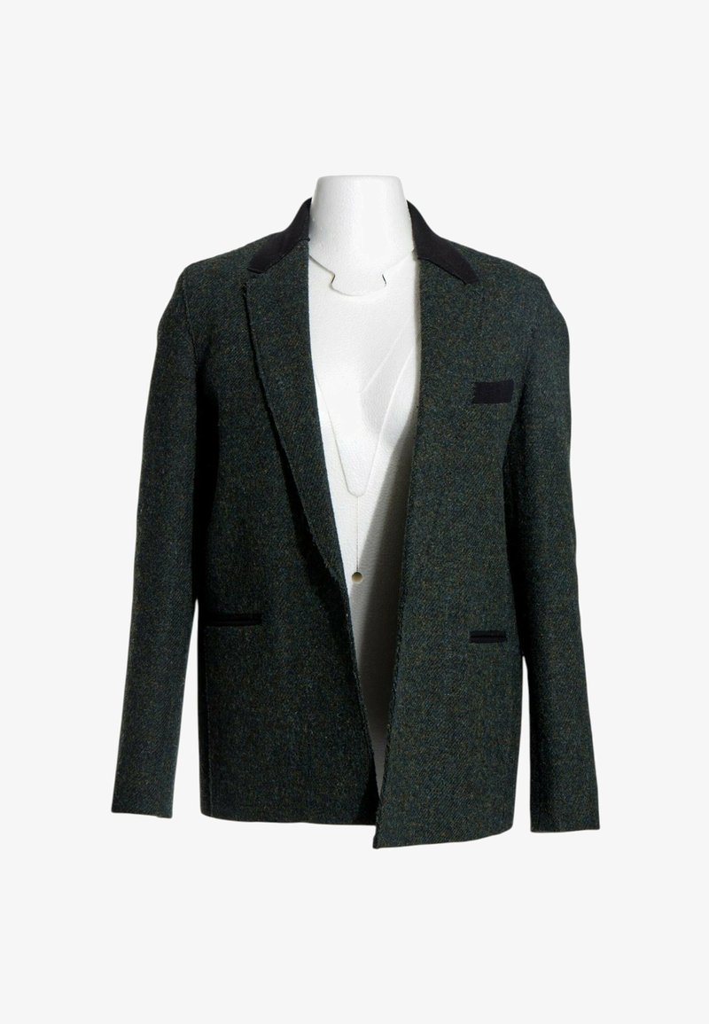 Blazer en laine vert foncé avec col noir et détails de poche présenté sur un buste de mannequin blanc sur fond blanc.