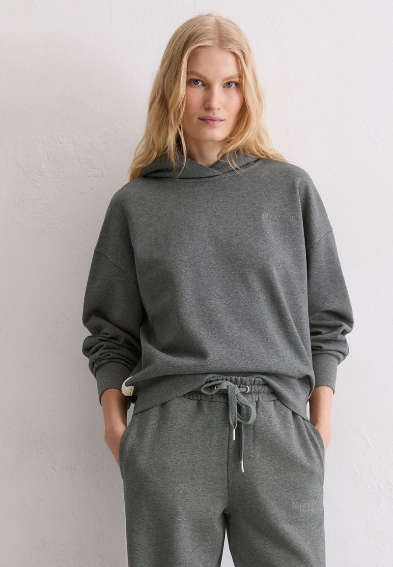 Szara bawełniana bluza z kapturem z troczkiem, luźny krój, ściągacze przy mankietach, w połączeniu z dopasowanymi szarymi spodniami dresowymi z bocznymi kieszeniami.