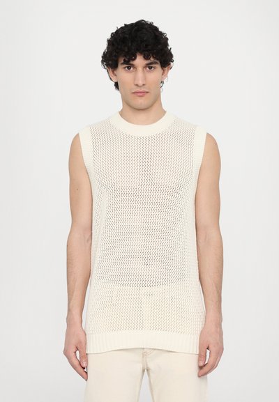 Top senza maniche di colore avorio, realizzato in maglia con una trama a rete aperta, colletto e orlo arricciati. Il tessuto è leggero e traspirante.