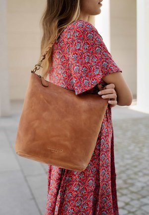 Tan leather shoulder bag with a smooth texture, featuring a single strap and a small logo embossed on the bottom.