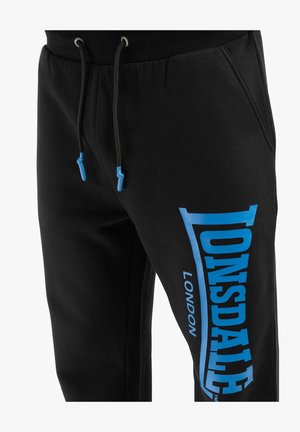 Mustad mustad koos elastse vöökoha ja siniste paeltega, millel on vasakul jalal suur sinine logo. Pehme puuvillane materjal.