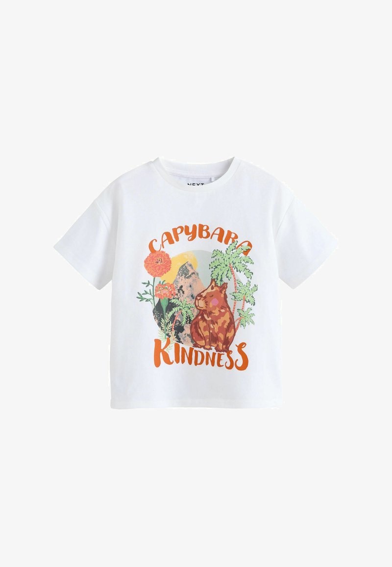 T-shirt blanc à manches courtes avec un capybara assis, des fleurs colorées, des palmiers et les mots « Capybara Kindness » en lettres orange.