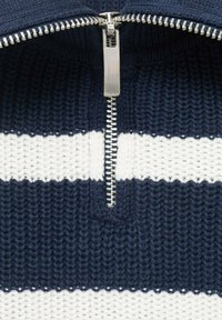 Granatowy i biały sweter typu knit w paski z pół-zipem, wyposażony w srebrny zamek i żebrowaną teksturę wokół dekoltu.