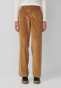 Bruine corduroy broek met een recht model, voorzien van een knoopsluiting, riemlussen en opgerolde manchetten. Vliezen textuur met verticale ribbels.