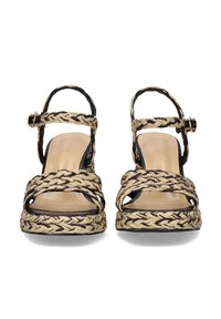 Sandalias de esparto trenzadas en negro y beige con tacón en cuña, punta abierta y tira para el tobillo. Plantilla de cuero suave con suela texturizada.