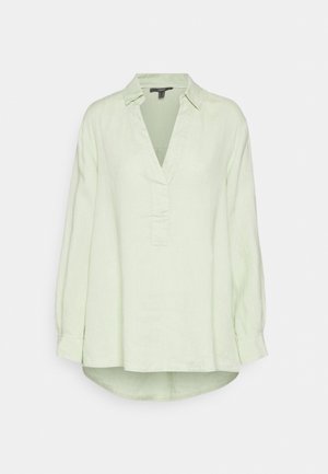 Chemise à manches longues en lin vert clair avec un col en V, patte de boutonnage et ourlet légèrement courbé. Dispose de poignets avec fermeture à bouton.