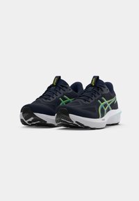 Navy running shoes with green accents, mesh upper, thick white and black sole, and reinforced toe. Features logo on tongue and side.