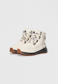 Cream-colored winter boots feature a padded design, black rubber sole, and striped laces with logo details on the sides.