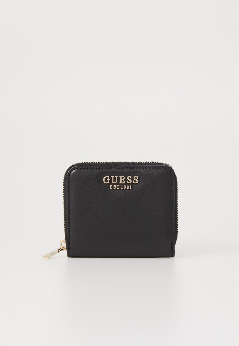 Black zippered wallet with gold "GUESS EST 1981" logo. Made of smooth material, featuring a compact rectangular design and a small zipper pull.