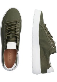 Sneakers in tela color verde oliva con suole in gomma bianca, punta tonda e occhielli in metallo. Presentano un logo sulla linguetta e accenti laterali testurizzati.