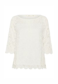 Top in pizzo bianco con scollatura rotonda e maniche a tre quarti. Orlo ondulato, con motivi floreali su tutto il tessuto.