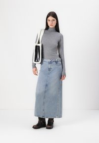 Gray fitted turtleneck, light blue denim maxi skirt, black ankle boots with buckle accents, and a black-and-white textured shoulder bag.