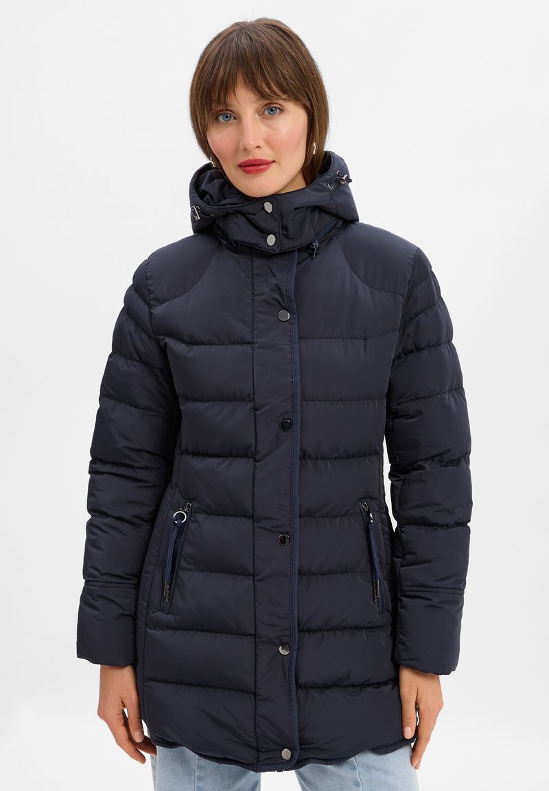 Granatowa kurtka puchowa z zapięciem na zamek i napy, kaptur, oraz dwiema kieszeniami bocznymi na zamek. Posiada pikowany wzór i miękką teksturę.