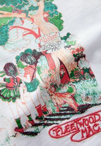 Fehér szövet két gyermeket ábrázoló illusztrációval egy fa mellett, piros és zöld díszítésekkel. A szöveg így szól: "Kiln House Fleetwood Mac."