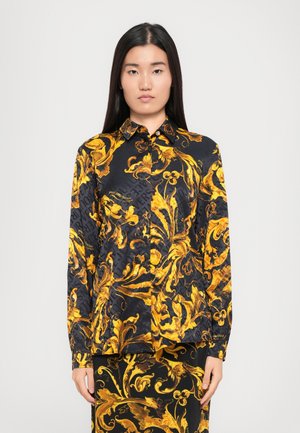 Zwarte shirt met gouden barokke bloemenpatroon, lange mouwen, puntige kraag en knoopsluiting, gemaakt van een gladde, glanzende stof.